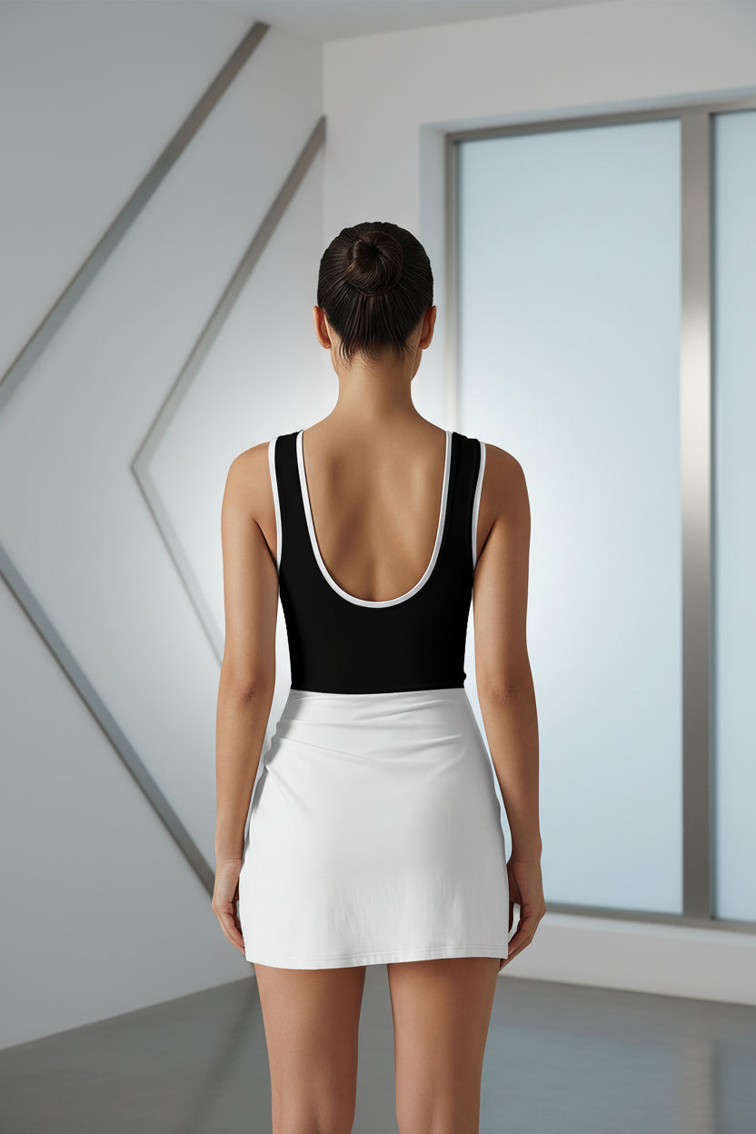Woman wearing a black and white bodysuit with a skirt in a room