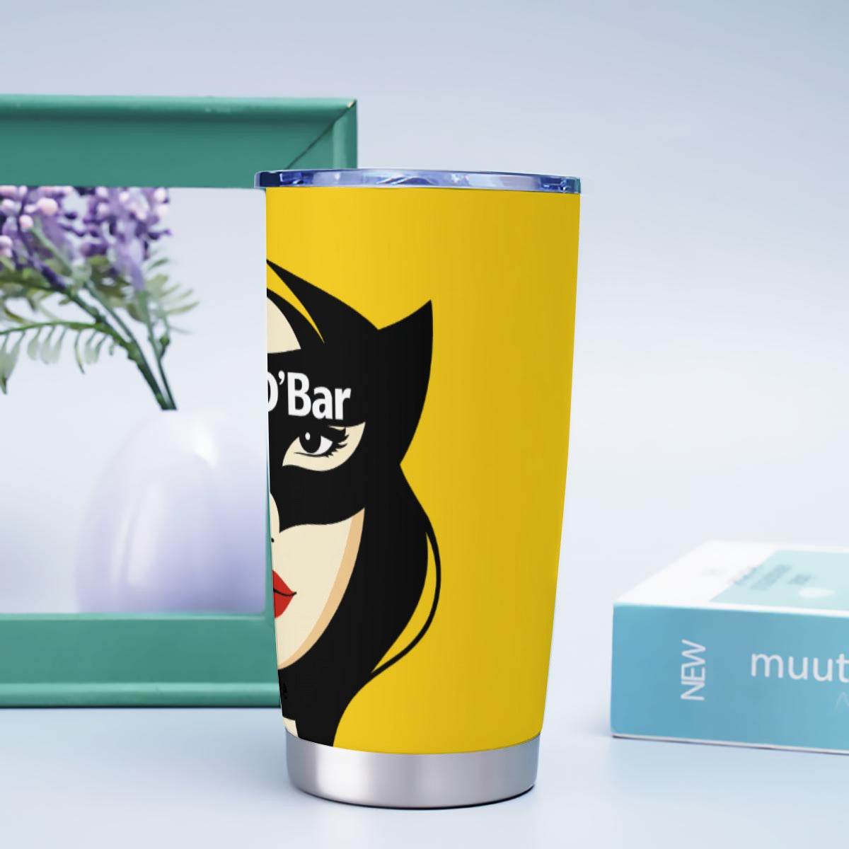 Yellow tumbler with a graphic design on a light blue background