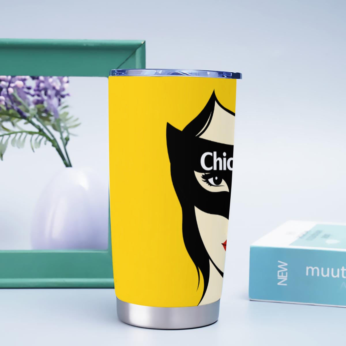 Yellow tumbler with a graphic design on a light blue background