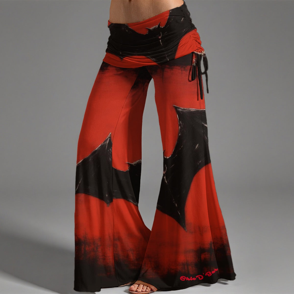 A woman with a red and black bell-bottom bat woman pants on a black chair in a castle.